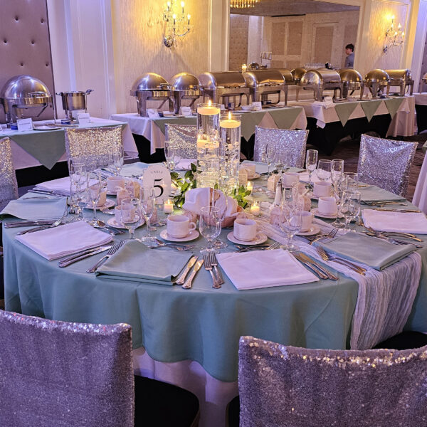 3 glass cylinders with floating candles, filled with clear water gel beads and decorated with acrylic diamonds, pearls, and floating candles, placed on a 12in mirror charger, surrounded by white/ivory rose garland and fairy lights, decorations, candle ceremony, Queen Tiffany throne, table setup, centerpieces, gold pedals for Victoria's Sweet 16 in Staten Island, New York at the Grand Plaza done by PMT Party Services Group