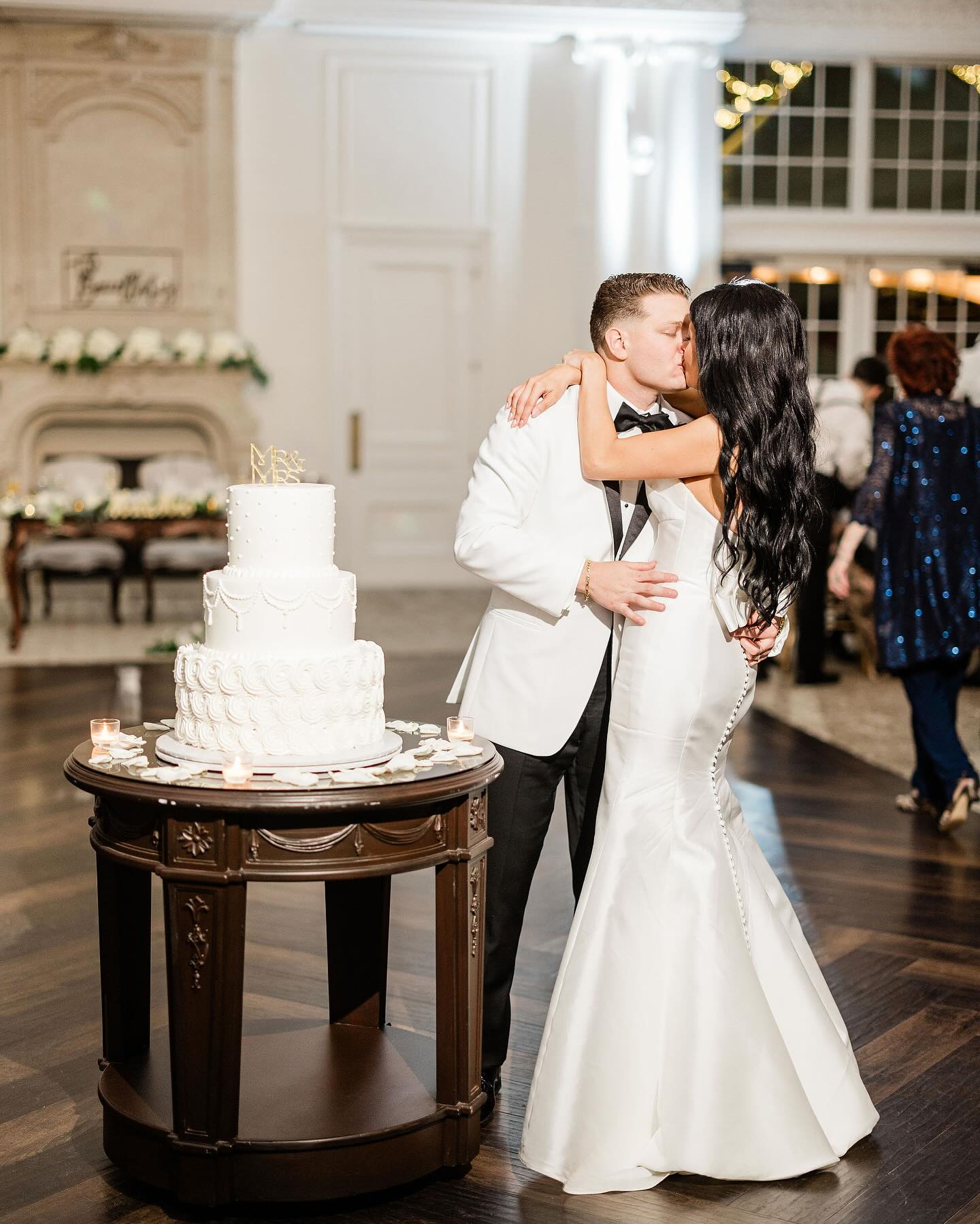 Gold centerpiece with white ostrich feathers on a glass mirror base with votive candles at the Park Chateau in New Jersey done by PMT Party Services Group