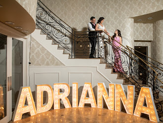 Adrianna's Sweet 16: Adrianna with her parents and 4ft tall marquee letters that spell out ADRIANNA with warm lights at the bottom of the grand staircase at the Vanderbilt in Staten Island, New York done by PMT Party Services Group